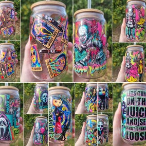May include: A clear glass tumbler with a bamboo lid and straw, featuring colourful graphic prints of horror movie characters and icons, including Pennywise, Ghostface, and Coraline, with text overlays like Ghost Face and The Dreamer.