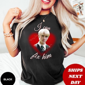 Może przedstawiać: Czarny t-shirt z czerwoną grafiką w kształcie serca z portretem i napisem "I can fix him". Koszulka ma r&oacute;wnież napisy "Cherry Way" i "Davis" w grafice serca.