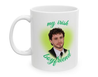 Może przedstawiać: Biały kubek ceramiczny z zielonym nadrukiem, na którym widnieje napis "my irish boyfriend". Nadruk zawiera również zdjęcie mężczyzny z brązowymi włosami.