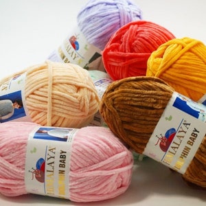 May include: Assortment of colorful yarn skeins in various shades of pink, orange, yellow, brown, and purple. The yarn is soft and fluffy, perfect for knitting or crocheting baby blankets, sweaters, and other projects. Each skein has a label with the brand name "Himalaya" and the text "Soft Baby".