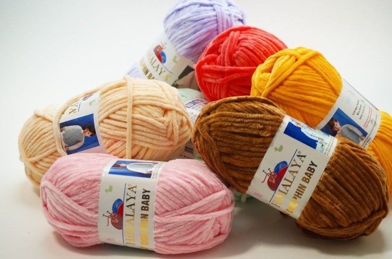 May include: Assortment of colorful yarn skeins in various shades of pink, orange, yellow, brown, and purple. The yarn is soft and fluffy, perfect for knitting or crocheting baby blankets, sweaters, and other projects. Each skein has a label with the brand name "Himalaya" and the text "Soft Baby".
