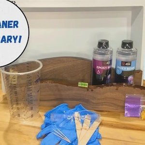 May include: A woodworking kit with epoxy resin, mixing cups, gloves, and stir sticks. The kit includes two bottles of epoxy resin, a level, and small bags of materials. The text "NO PLANER NECESSARY!" is in a white circle.