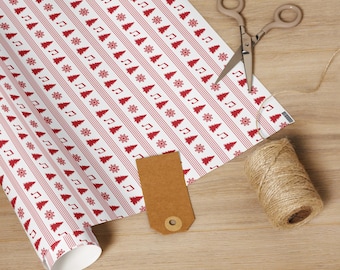 May include: White wrapping paper with a red Christmas tree, musical note, and snowflake pattern. A pair of scissors, a brown tag, and a spool of twine are on a wooden surface, ready for gift wrapping.