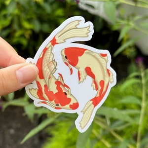 May include: A sticker featuring two koi fish swimming in a circle. The fish are white with red markings. The sticker is on a white background.