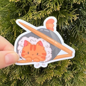 May include: A sticker of a cartoon orange cat inside a sushi roll with chopsticks. The cat is looking at the viewer with a cute expression.