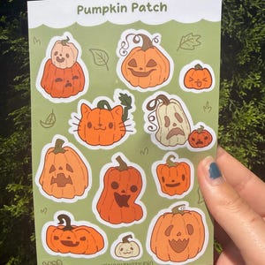 May include: A rectangular sticker sheet titled Pumpkin Patch featuring various orange and cream-colored pumpkin illustrations with different facial expressions, including a cat-shaped pumpkin, all set against a light green background with leaf outlines.
