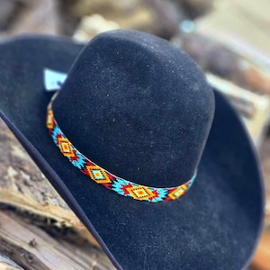 May include: A black felt cowboy hat with a turquoise, orange, and yellow beaded band.