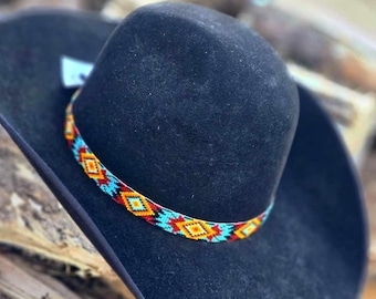 May include: A black felt cowboy hat with a turquoise, orange, and yellow beaded band.