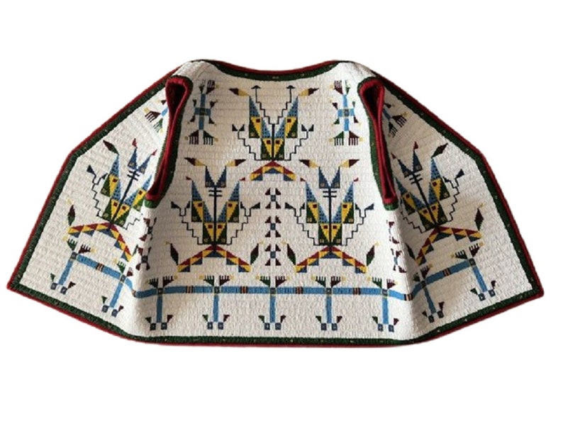 May include: A white sleeveless vest featuring a repeating geometric pattern in blue, yellow, green, and red. The garment has a dark green trim along the edges and a red inner lining, showcasing a structured, quilted texture throughout the fabric.