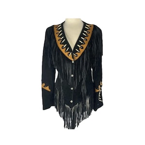 May include: Black suede jacket with fringe detailing. The jacket features a V-neck with tan and white accents, fringe along the sleeves, and a button-down front. The jacket has tan leather accents on the sleeves.