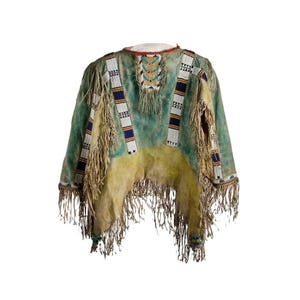 May include: A Native American-style poncho with a turquoise and yellow color scheme. The garment features intricate beadwork in white, blue, and black, along with long fringe detailing. The poncho is made of a soft, textured material.