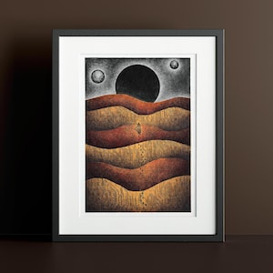 May include: A framed print of a black and white illustration depicting a lone figure walking across a landscape of rolling hills under a dark sky with three celestial bodies.