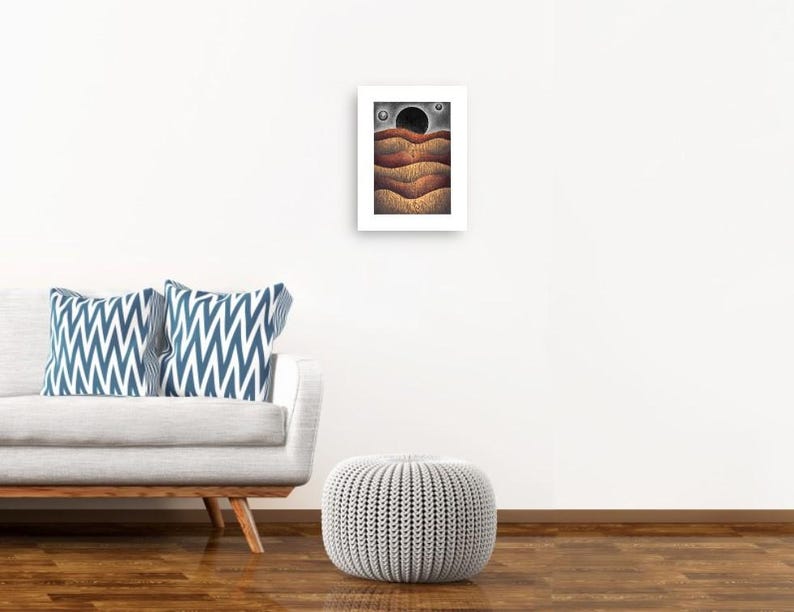 May include: A digital art print of a landscape with a black circle in the sky and brown, orange, and yellow hills. The print is framed in a white frame.