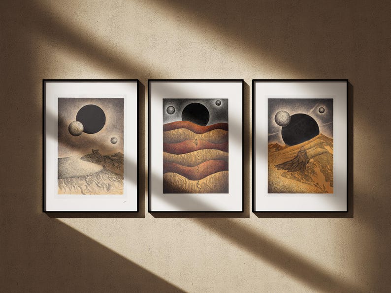 May include: Three framed prints with black frames and white mats. Each print features a black and white illustration of a landscape with a large black circle and smaller white circles in the sky. The landscapes are different in each print.