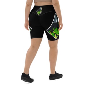 May include: Black biker shorts with a high waist and a green and black graphic print of a creature with a crown.