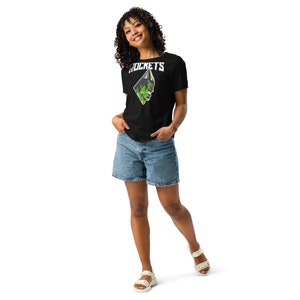 May include: A woman wearing a black t-shirt with a green and white graphic of a cartoon character and the word "ROCKETS" on it. She is also wearing denim shorts and white sandals.