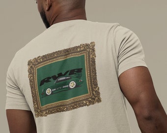 Puede incluir: Camiseta beige de manga corta con un gráfico enmarcado en la espalda. El gráfico muestra un coche deportivo verde con el texto "RWB" en negro. El marco tiene un diseño dorado ornamentado. La camiseta es de algodón.