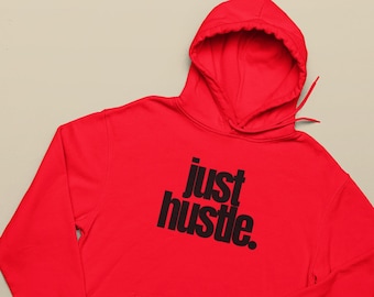 May include: A vibrant red hoodie with a hood and a front pocket. The hoodie features the phrase "just hustle" printed in bold black letters across the chest. A casual and comfortable garment.