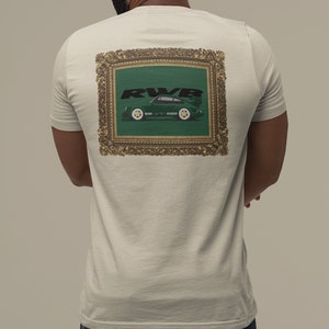 May include: Beige t-shirt with a framed graphic on the back. The graphic features a green sports car with the text "RWB" in black. The car is set against a green background within a gold ornate frame.