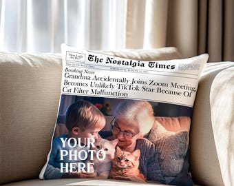 May include: A throw pillow with a newspaper design featuring a photo of a grandmother, a child, and a cat. The headline reads "Grandma Accidentally Joins Zoom Meeting, Becomes Unlikely TikTok Star Because Of Cat Filter Malfunction". The text "YOUR PHOTO HERE" is printed on the pillow.