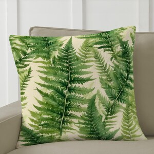 May include: A green and white throw pillow with a fern pattern. The pillow is on a beige couch. "Country Living Style" and "Nature-Inspired Wellness Decor" are printed below the pillow.