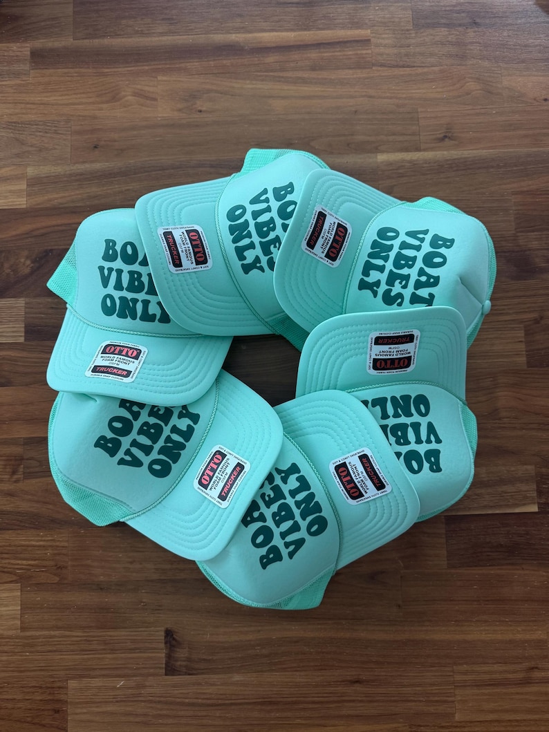 May include: A collection of light mint green trucker hats featuring a mesh back and a foam front panel. Each hat displays the dark green text "BOAT VIBES ONLY" printed on the front and includes an attached Otto brand tag on the brim.