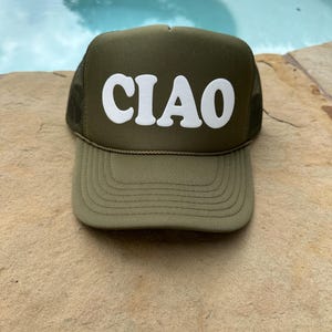May include: A green trucker hat with a white "CIAO" logo in a retro font.