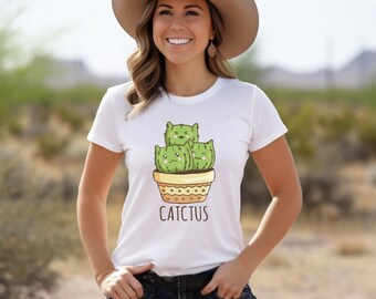 May include: White t-shirt featuring a graphic of three cartoon cacti in a pot. The cacti have smiling faces and the text "CATCTUS" is printed below the pot.