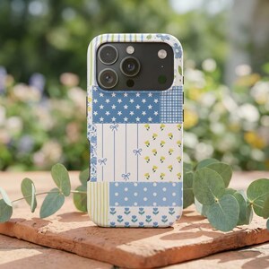 Könnte beinhalten: Gemusterte Handyhülle mit Patchwork-Design. Sie zeigt verschiedene Muster, darunter Sterne, Vichy, Schleifen und florale Motive. Die Farben sind Blau, Weiß und Gelb, was einen fröhlichen und dekorativen Look erzeugt.