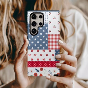 Könnte beinhalten: Eine gemusterte Handyhülle mit einem Patchwork-Design mit roten, weißen und blauen Elementen. Die Hülle enthält Sterne, Schleifen, Kirschen und Blumenmuster. Die Hülle ist für ein Smartphone konzipiert.