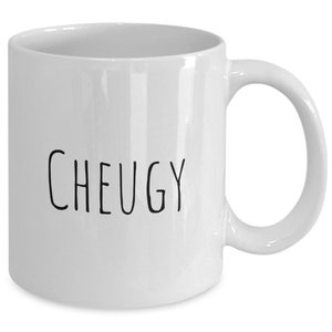 Puede incluir: Taza de café de cerámica blanca con texto negro que dice "CHEUGY".
