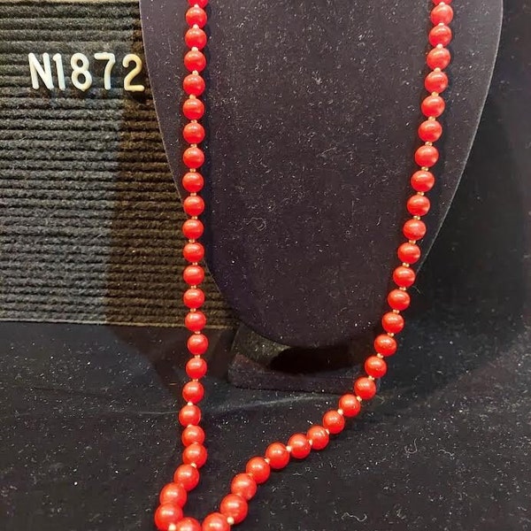 Red plastic beads with silver tone metallic finish seed beads between on 33" long continuous strand (knotted, no clasp). Light distressing.