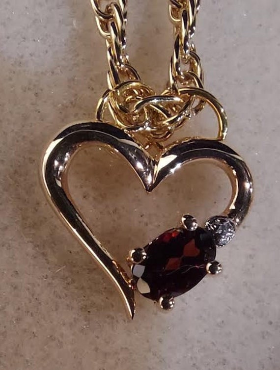 Gold tone heart shaped pendant features red facet… - image 4