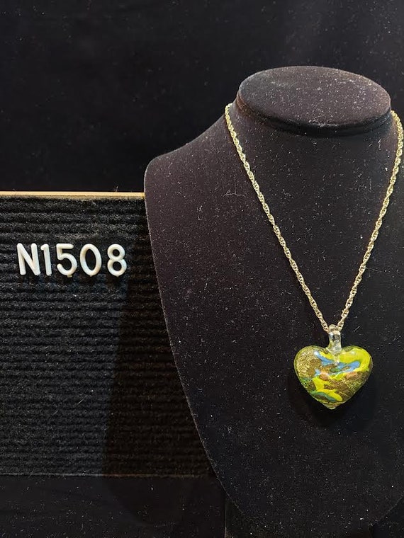 Heart shaped art glass pendant has encased gold to