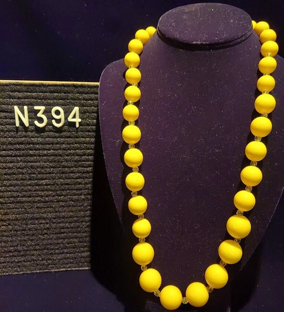 Necklace with graduated yellow beads having subtle