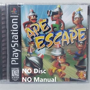 May include: A PlayStation game case for Ape Escape. The case is black with a colorful image of monkeys on the front. The text "NO Disc NO Manual" is printed on the front of the case.
