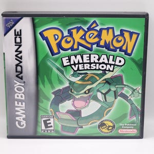 May include: A green Game Boy Advance game cartridge for Pokemon Emerald Version. The front of the cartridge features a green and black Pokemon character with the text "Pokemon Emerald Version" on the front.