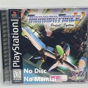 May include: A PlayStation game case for Thunder Force V: Perfect System. The case is black with a colorful image of a spaceship on the front. The text "No Disc" and "No Manual" is written on the front of the case.