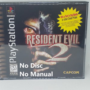 May include: A black PlayStation game case for Resident Evil 2. The case has a mature rating and a yellow star with the text "Win a Part in the Movie or other Great Prizes". The case is missing the disc and manual.