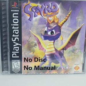May include: A PlayStation game case for Spyro the Dragon. The case is purple and yellow with a picture of Spyro on the front. The text "No Disc" and "No Manual" is written on the front of the case.