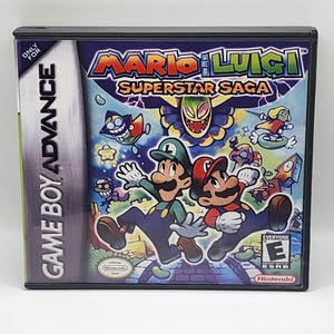 May include: A Game Boy Advance game cartridge for Mario & Luigi: Superstar Saga. The game features a green and red background with the title "Mario & Luigi: Superstar Saga" in white text. The characters Mario and Luigi are featured on the front of the cartridge.