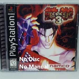 Puede incluir: Caja de juego de PlayStation para Tekken 3 con un diseño rojo, negro y blanco. La caja tiene una imagen de un personaje del juego. El texto "No Disc" y "No Manual" está impreso en la caja. La clasificación ESRB es Teen.