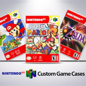 以下が含まれることがあります： カスタムアートワークを施したニンテンドー64ゲームケース3つ。ケースは赤で、スーパーマリオ64、ペーパーマリオ、ゼルダの伝説 時のオカリナが描かれている。