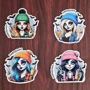 May include: Four digital stickers featuring a skull-faced girl with different colored hair and hats. Each girl is holding a beverage and has a peace sign. The stickers have a white border and the text "InkFlosStudios" is on each sticker.