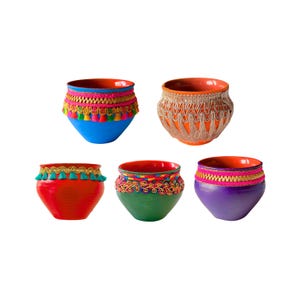 May include: Five small, round ceramic bowls in blue, orange, red, green, and purple, each featuring a distinct interior orange or red glaze. The exterior of each bowl is decorated with colorful fabric trim, including tassels, braided ribbons, and fringe.