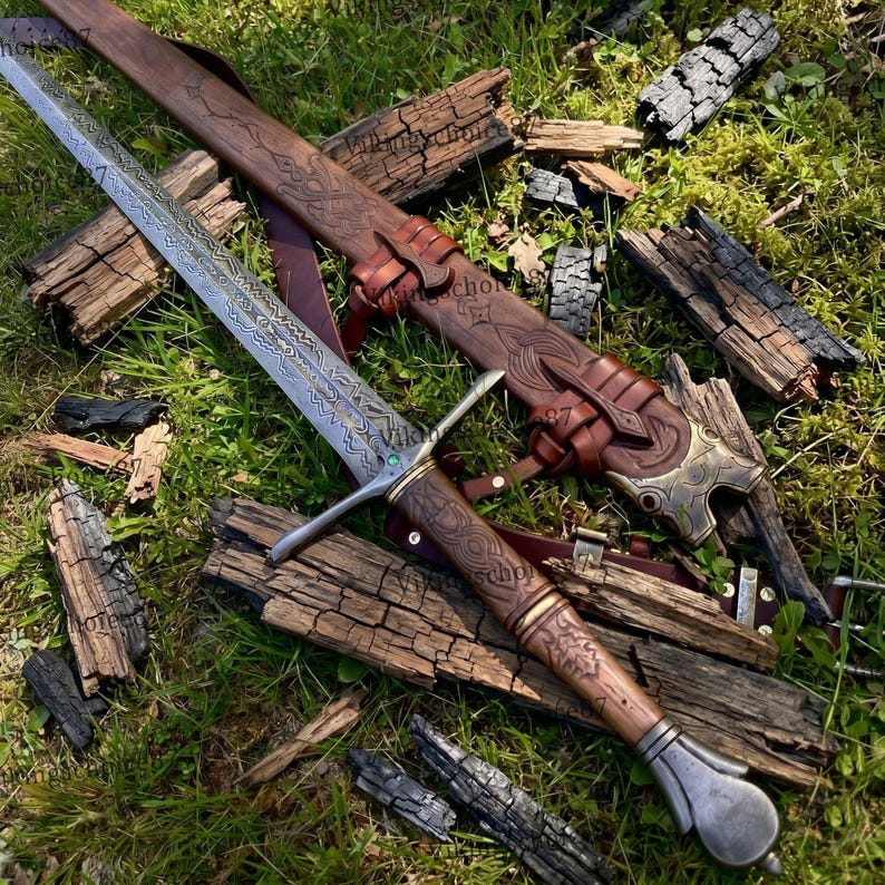 May include: A detailed image of a sword with a patterned blade and wooden handle, resting on a bed of grass and wood. The sword is accompanied by a brown leather sheath with intricate carvings and metal accents. The overall aesthetic is rustic and historical.