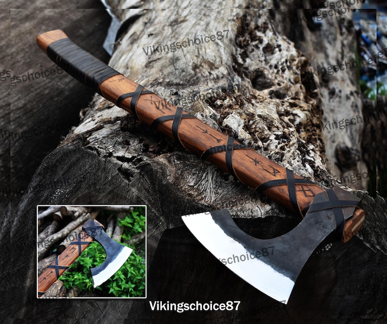 May include: A Viking axe with a wooden handle wrapped in black leather and a steel head. The handle is decorated with runes and the head is polished to a shine.