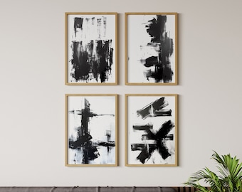 May include: Four black and white abstract paintings in wooden frames, hung on a white wall. The paintings feature bold brushstrokes and geometric shapes.