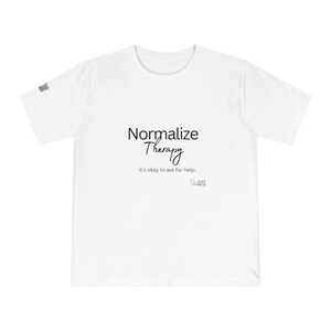 Puede incluir: Camiseta blanca con el texto "Normalizar la terapia" y la frase "Está bien pedir ayuda." en negro.