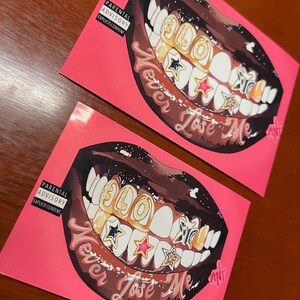 May include: A pink background with a black and brown illustration of a mouth with gold teeth and stars. The text "Never Lose Me" is written below the mouth.
